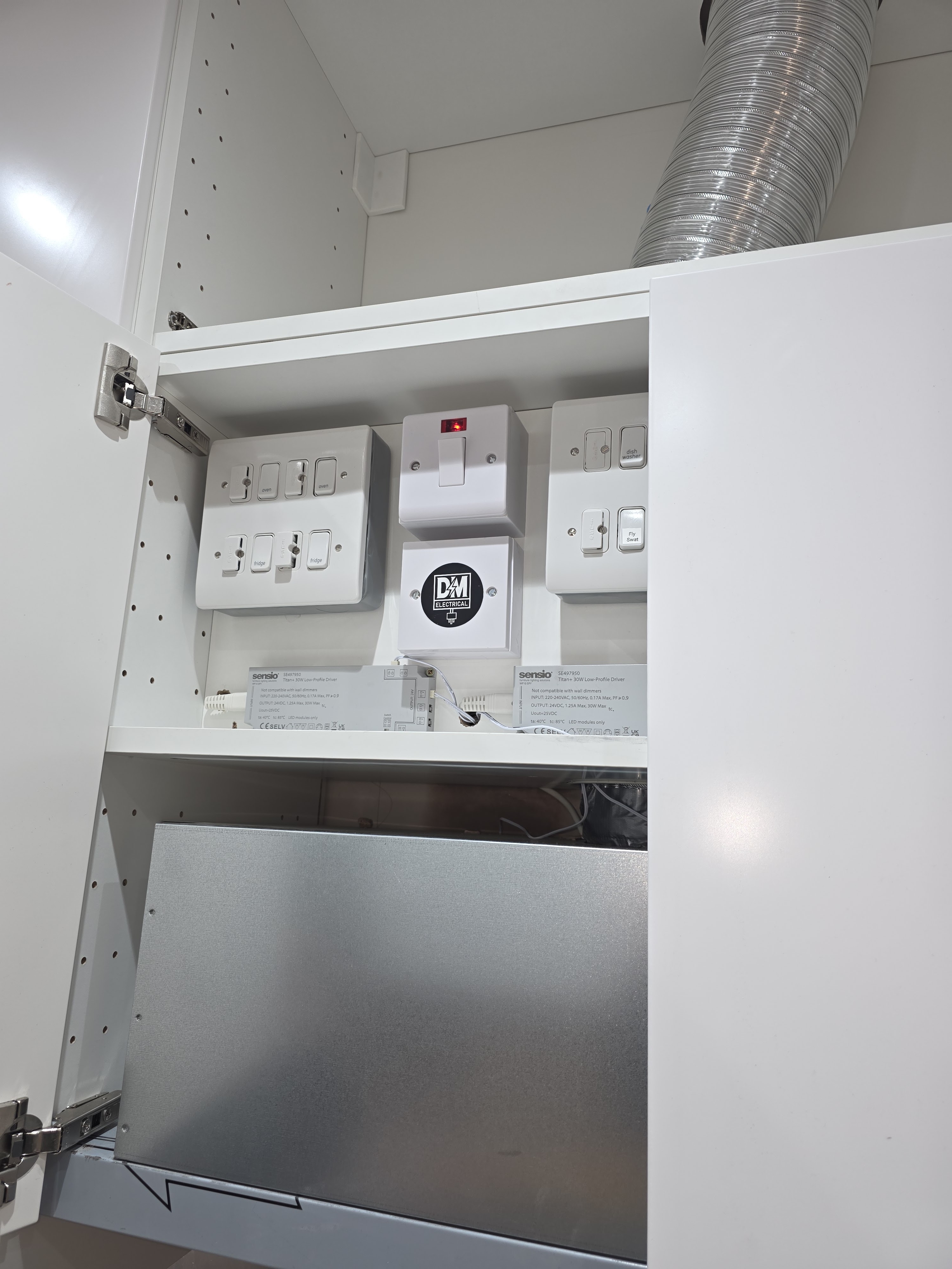 Completed appliance switches and connections neatly installed inside the cabinet