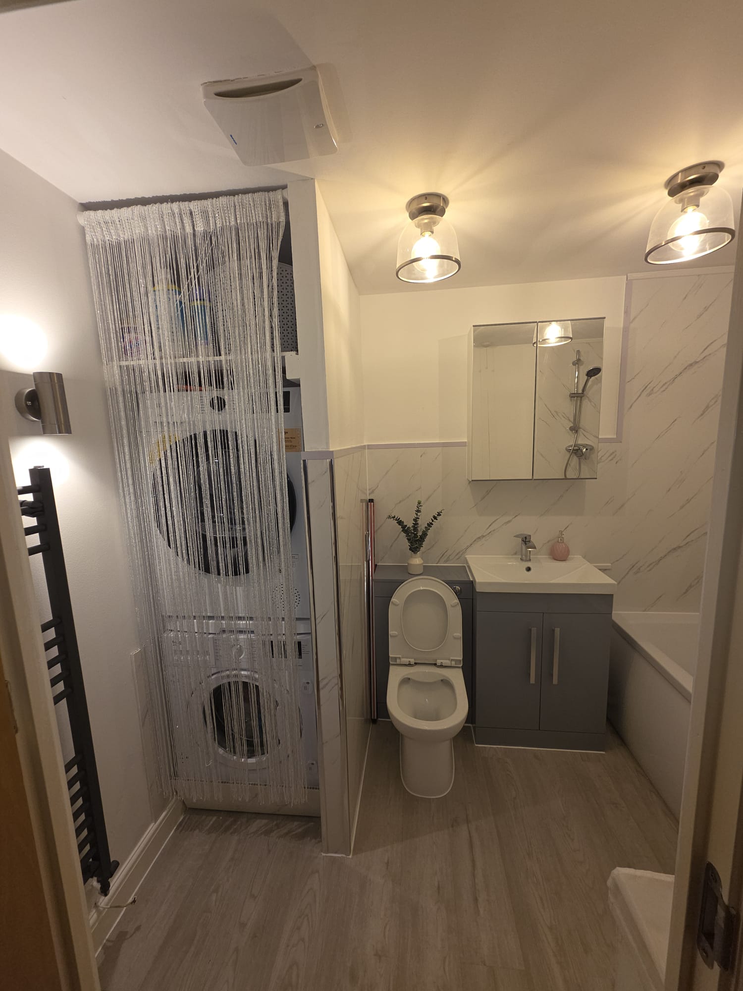 Completed bathroom with ceiling lights, wall lighting and an extractor fan